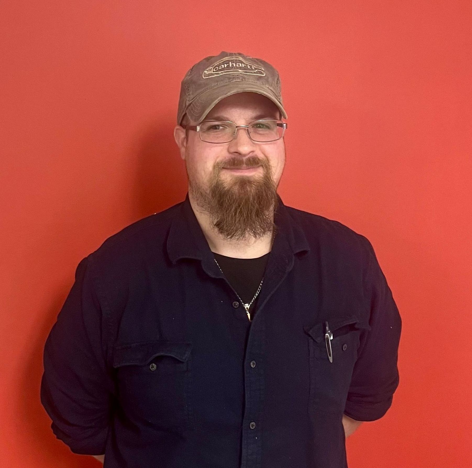 A man with a beard wearing a hat and glasses