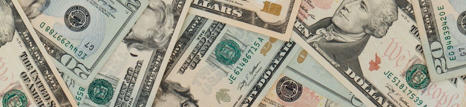 A pile of money is laying on a table.