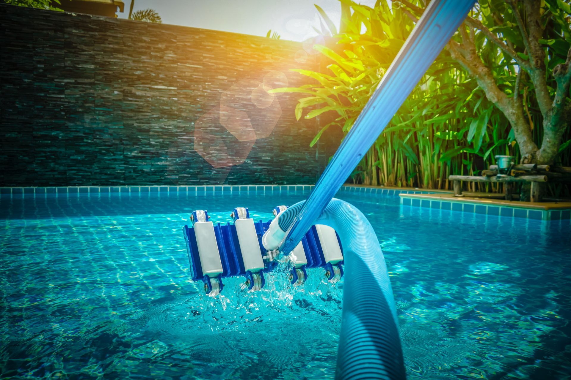 a pool suction cleaner being held up over a pool.