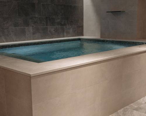 A large bathtub filled with water in a bathroom.