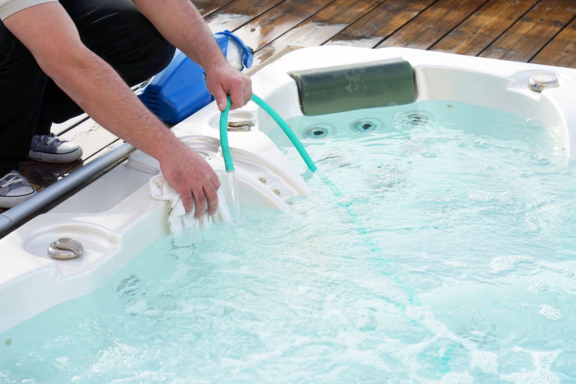a man filling a small spa with water.