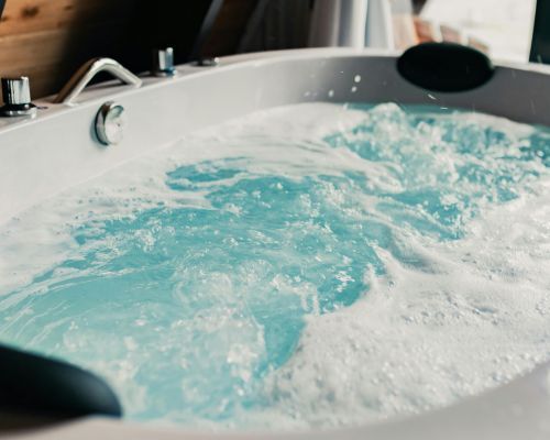 A jacuzzi tub filled with blue water and foam.