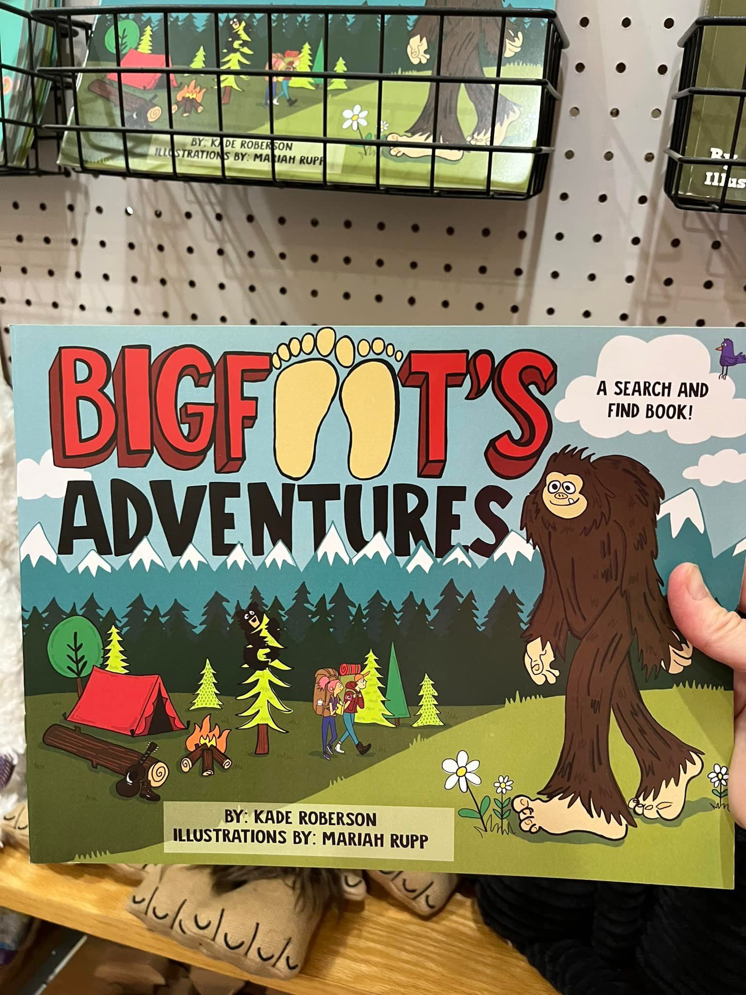 A person is holding a book titled bigfoot 's adventures