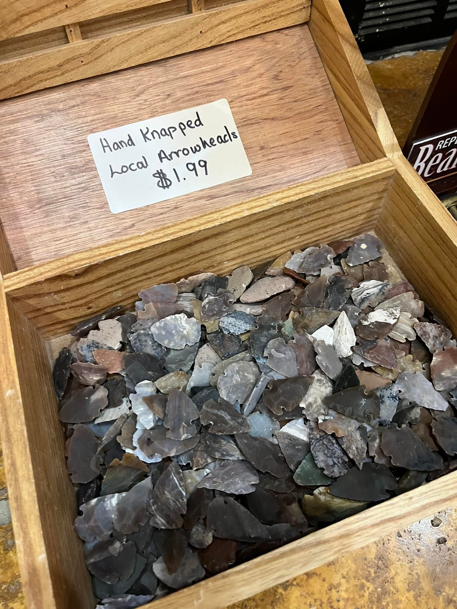 A wooden box filled with rocks and a price tag on it.