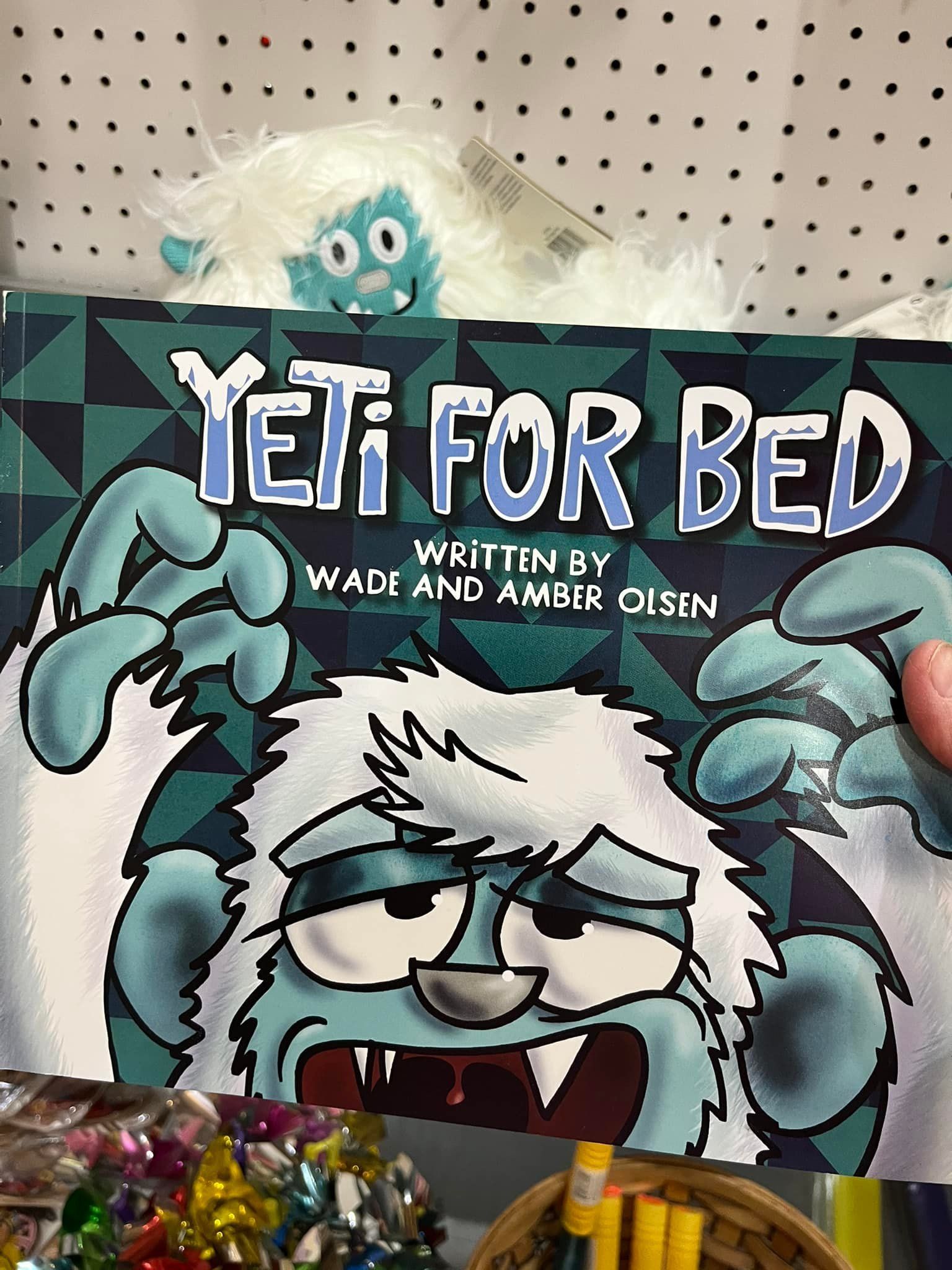 A person is holding a book titled yeti for bed