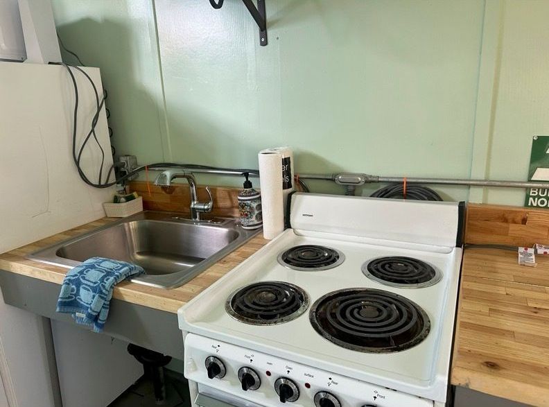 A kitchen with a stove , sink , and refrigerator.