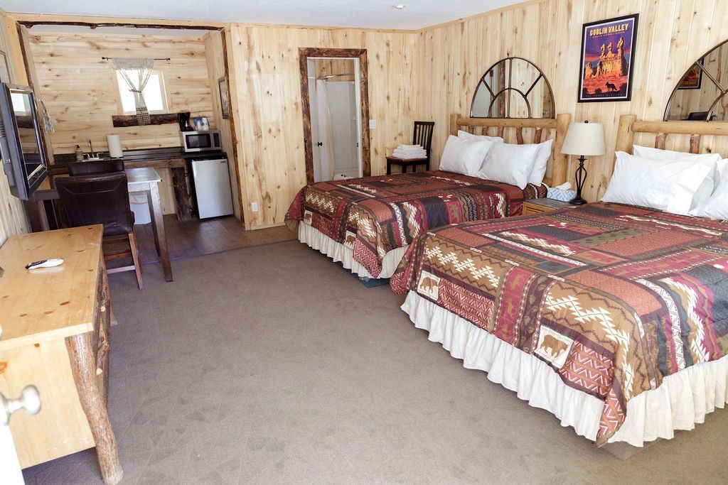 A hotel room with two beds and a desk