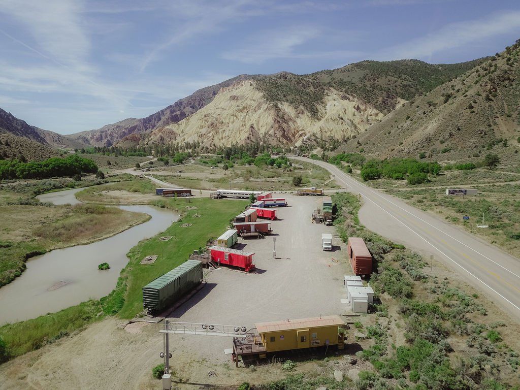 An aerial view of a train yard with mountains in the background