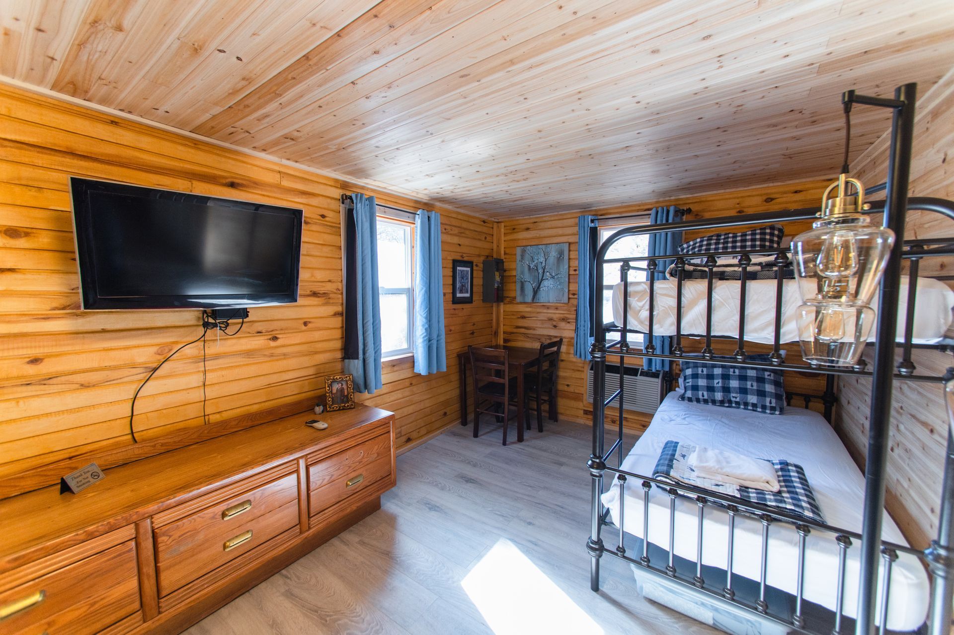 A bedroom in a log cabin with a bed and a flat screen tv.