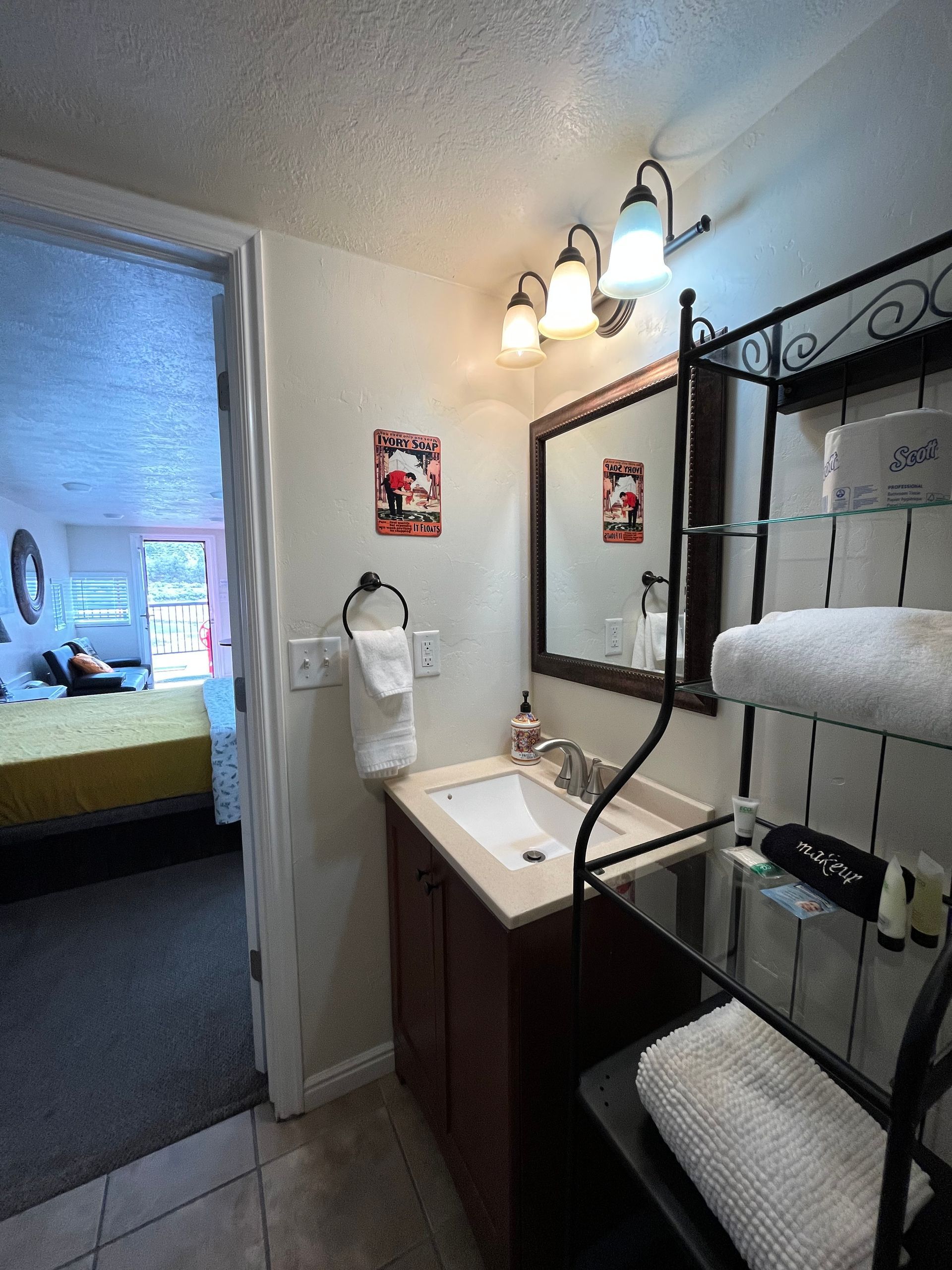 A bathroom with a sink , mirror , and towels.