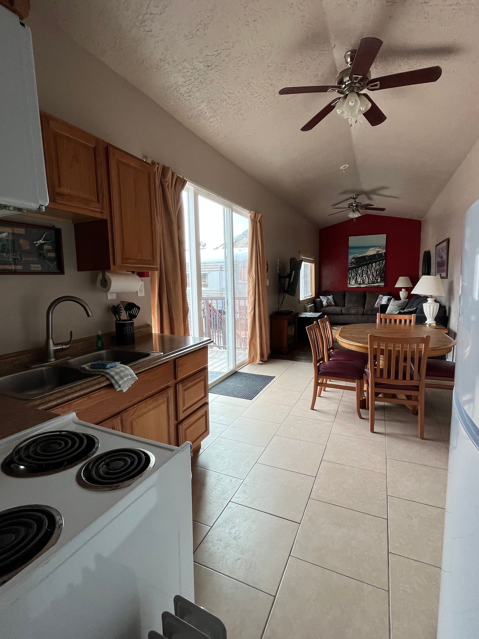 A kitchen with a stove and a ceiling fan