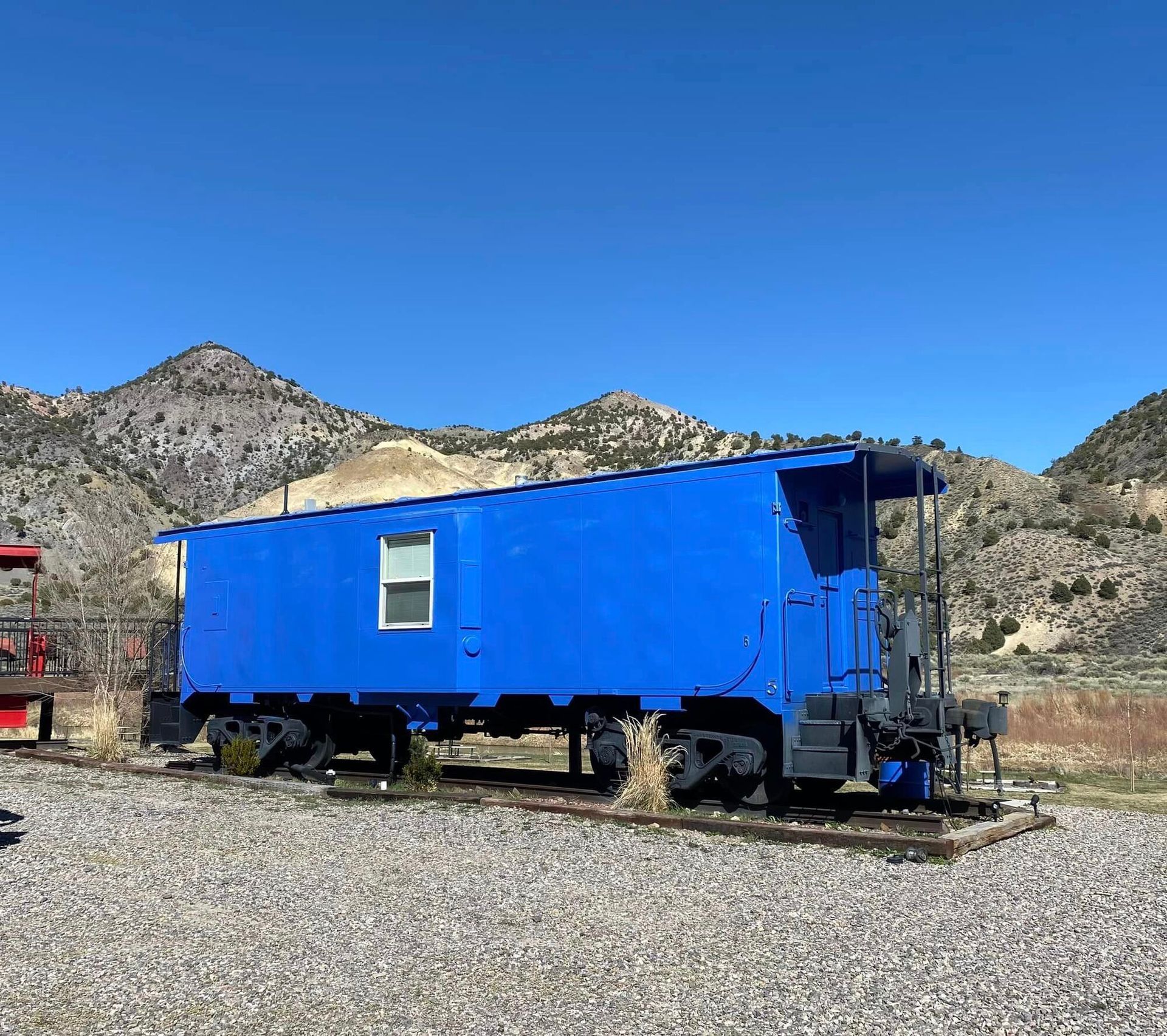 A blue train car with mountains in the background