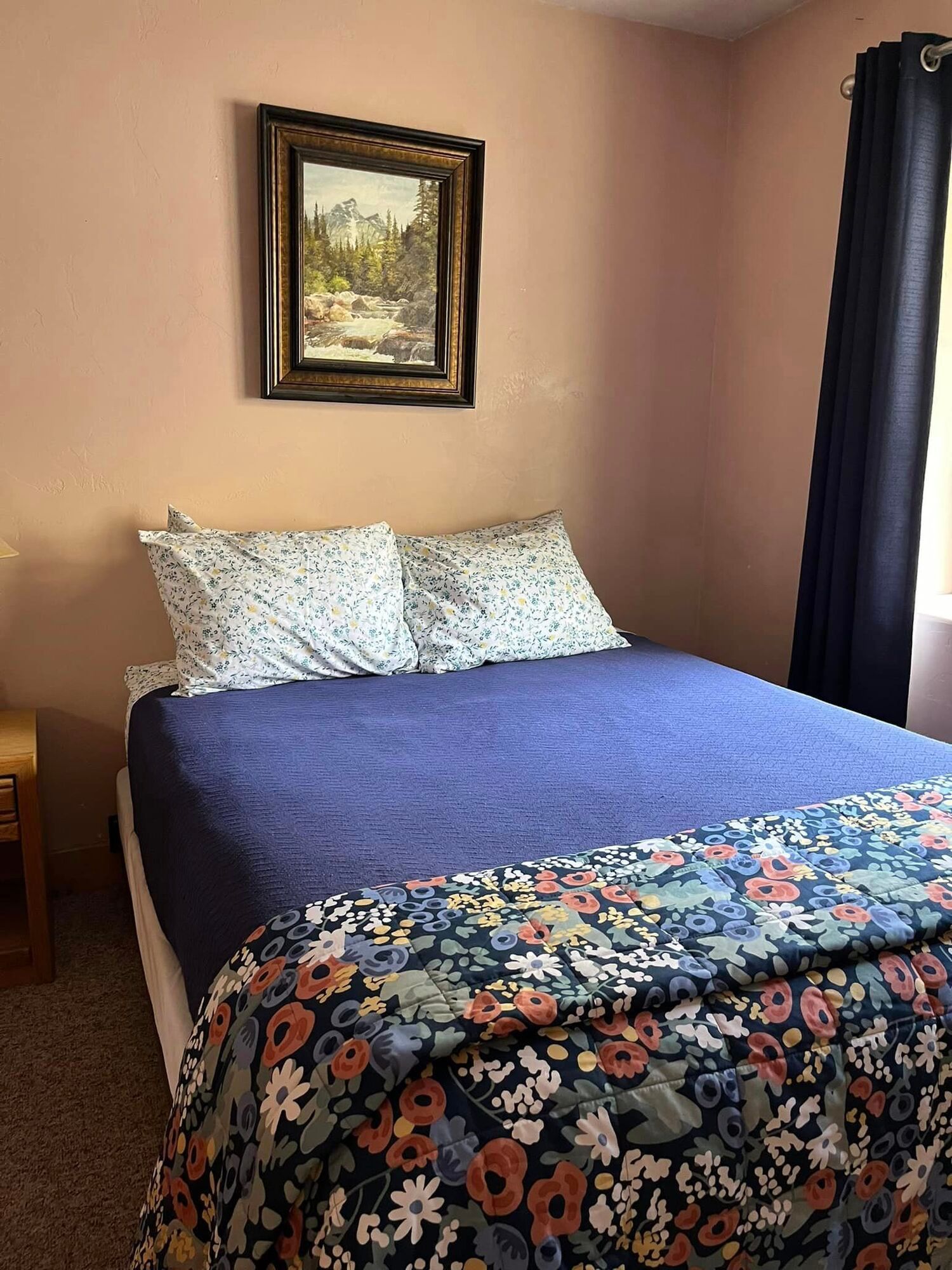 A bedroom with a bed and a painting on the wall.