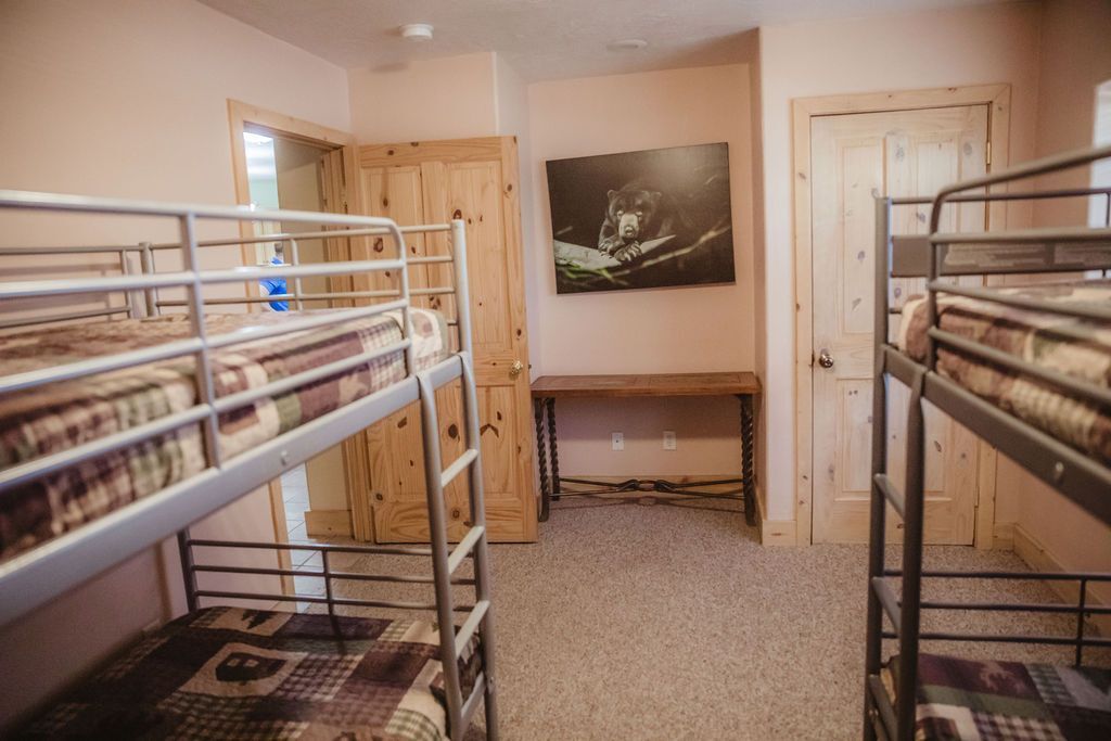 A bedroom with four bunk beds and a desk.