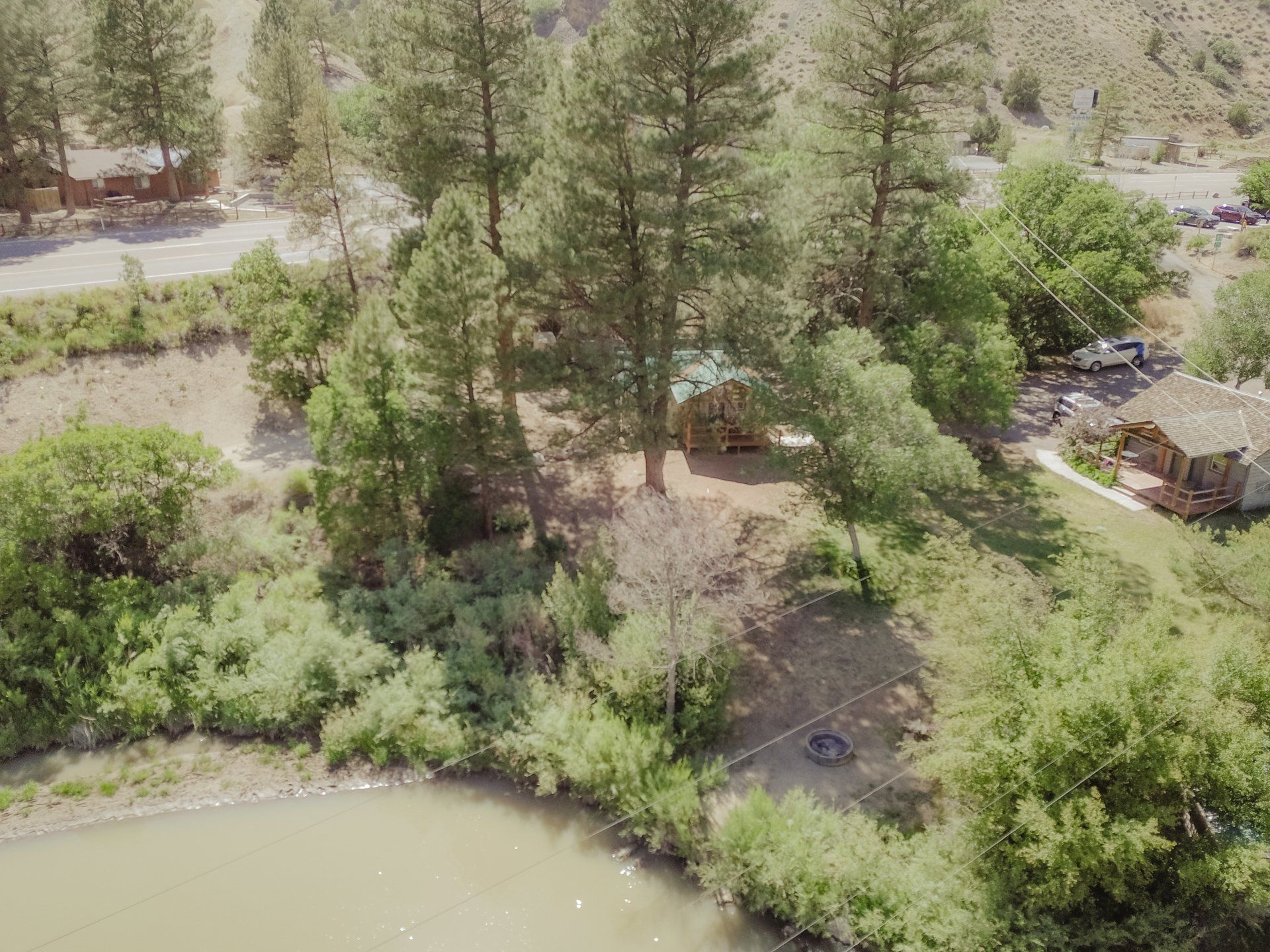 An aerial view of a lake surrounded by trees and a house.