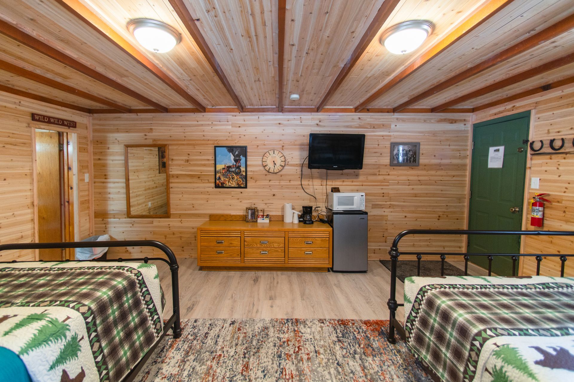 A cabin with two beds , a microwave , and a television.