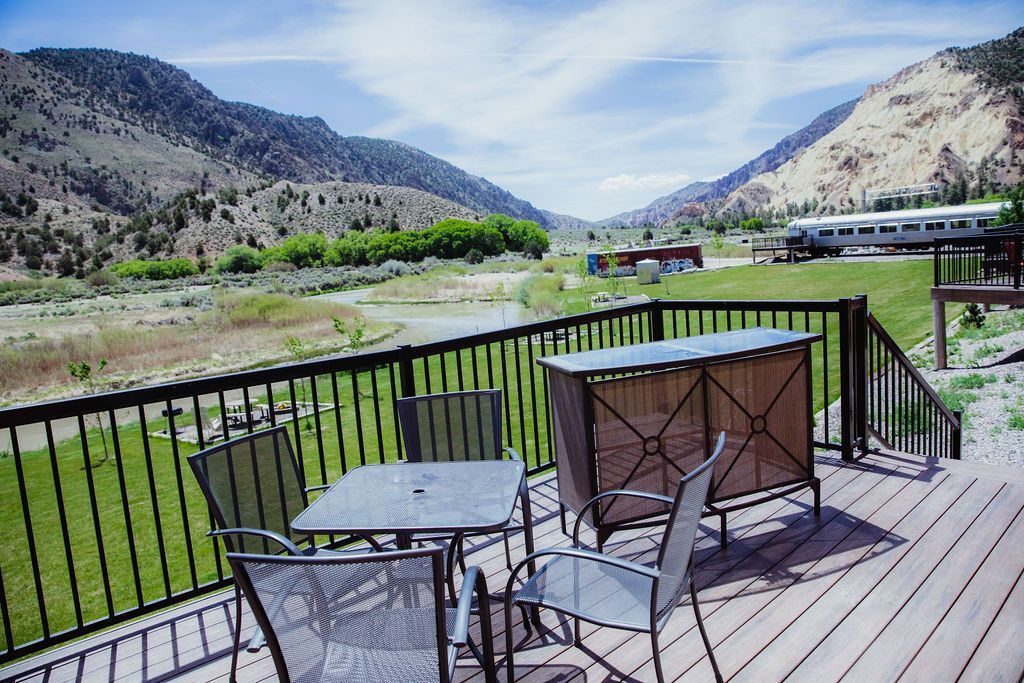 A deck with a table and chairs and a view of mountains