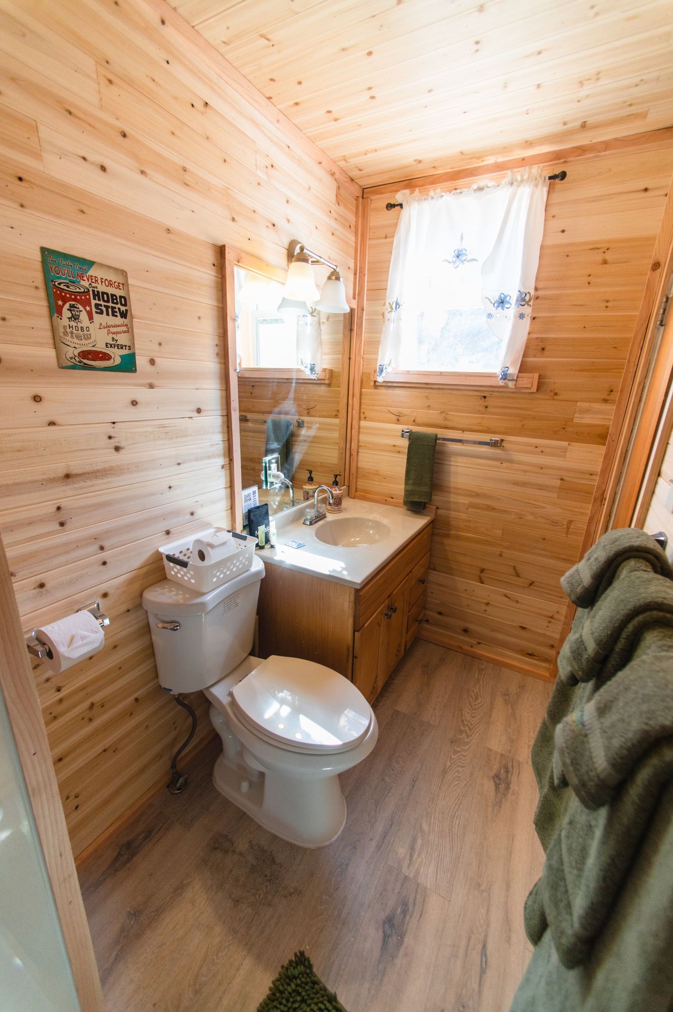 A bathroom with a toilet , sink and mirror.