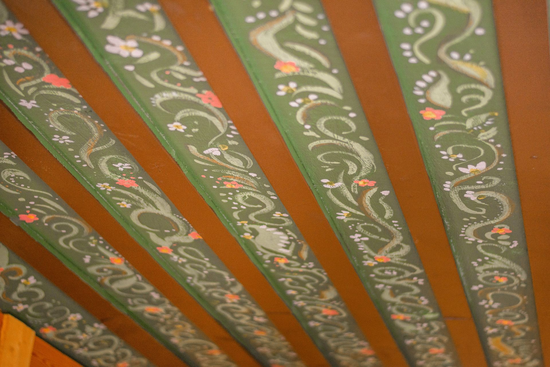 A ceiling with green and brown stripes and a floral design