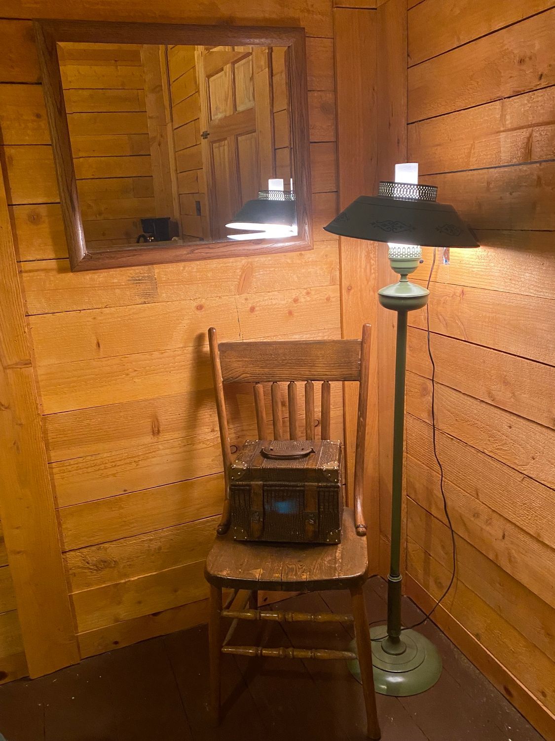 There is a chair and a lamp in the corner of the room.