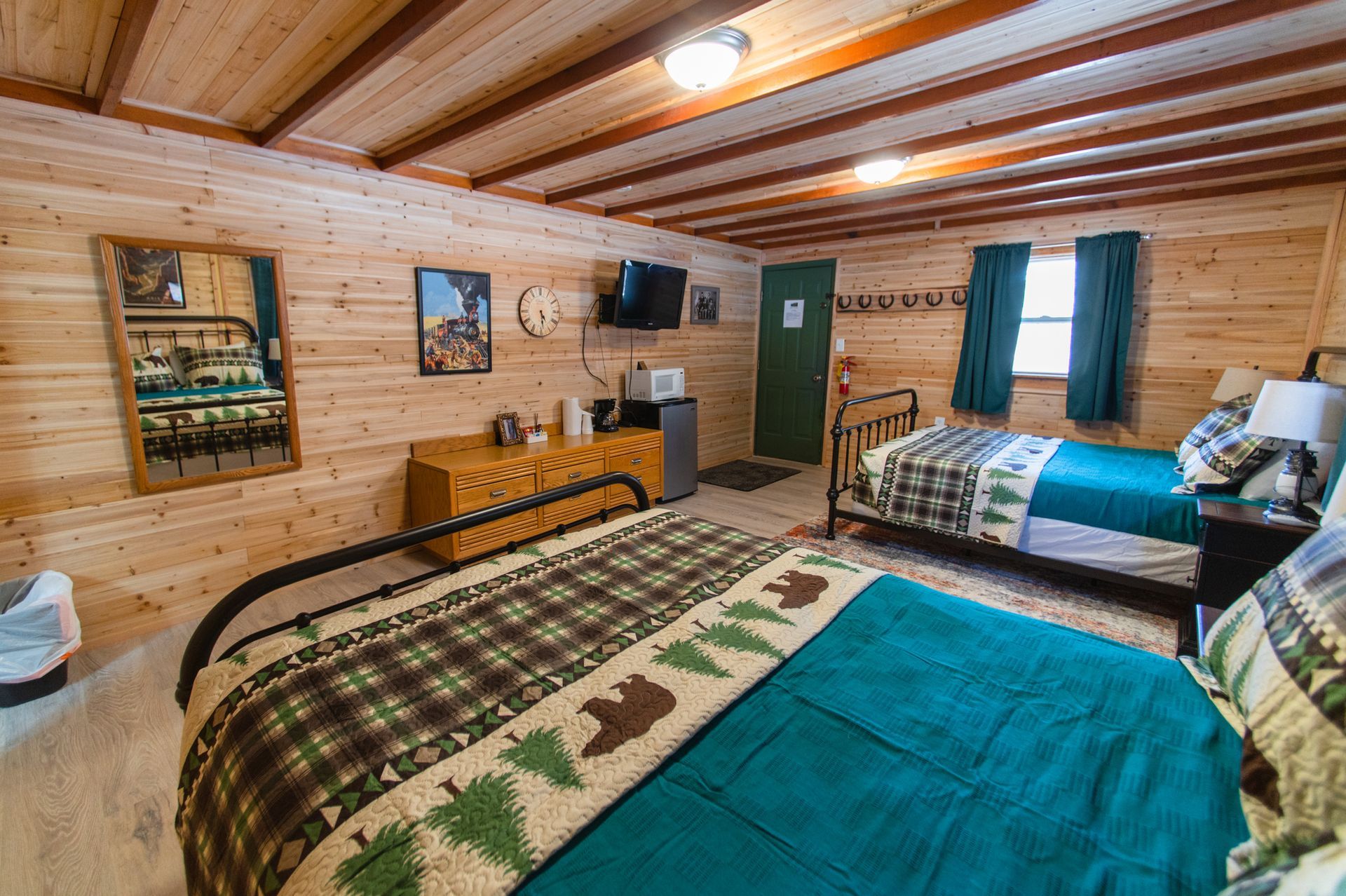 A wooden cabin with two beds and a dresser.
