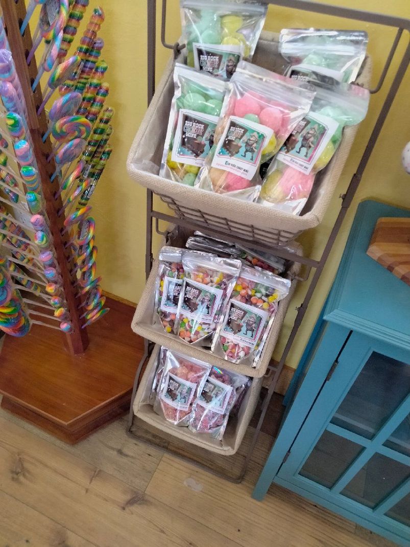 A shelf filled with bags of candy and lollipops.