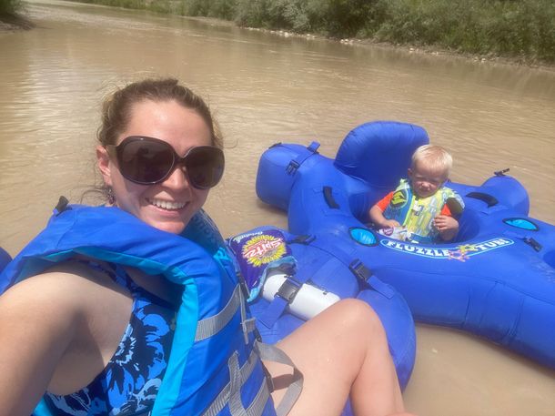 A woman and a child are floating down a river on rafts.
