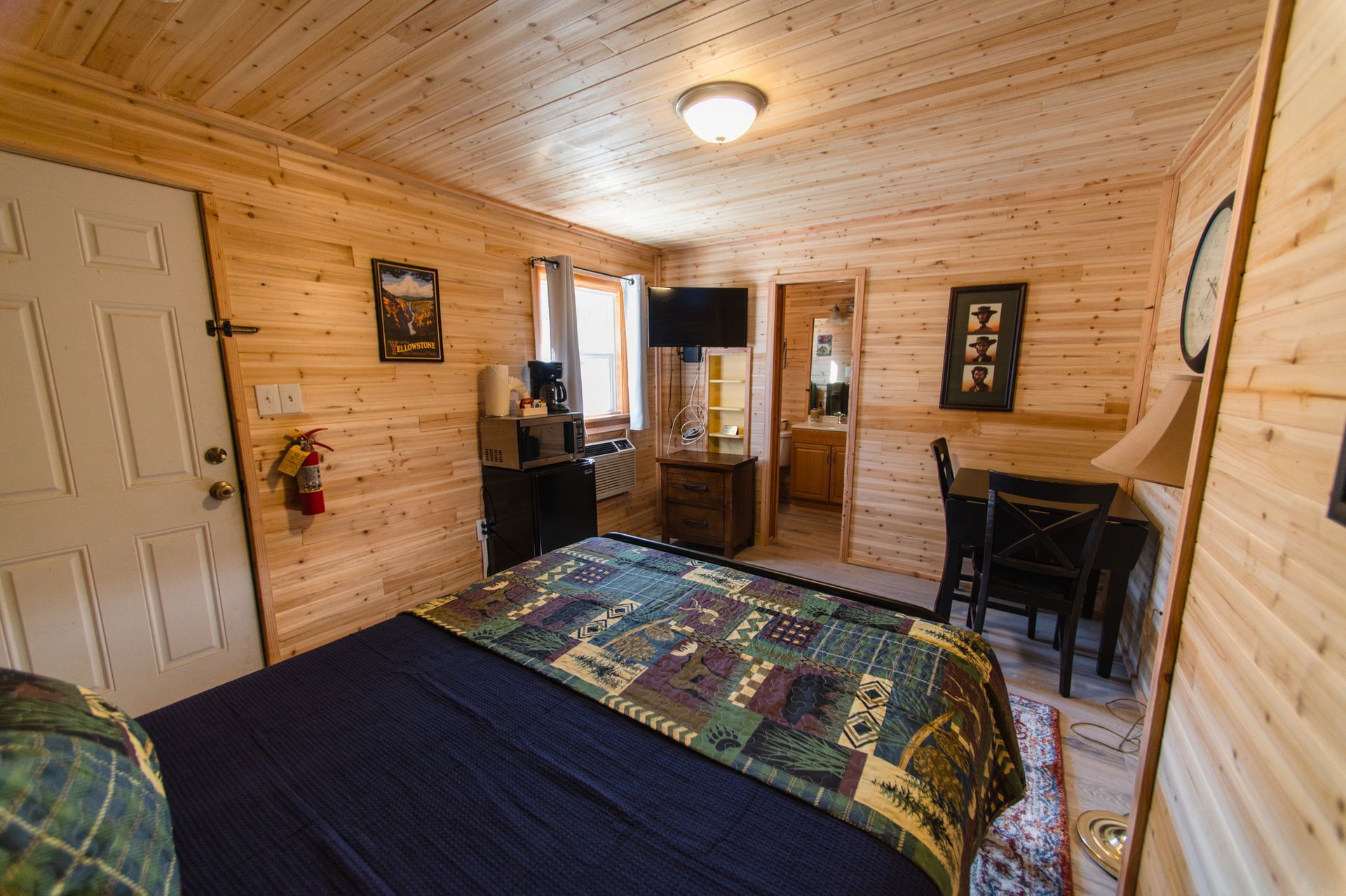 A bedroom in a log cabin with a king size bed and a table.