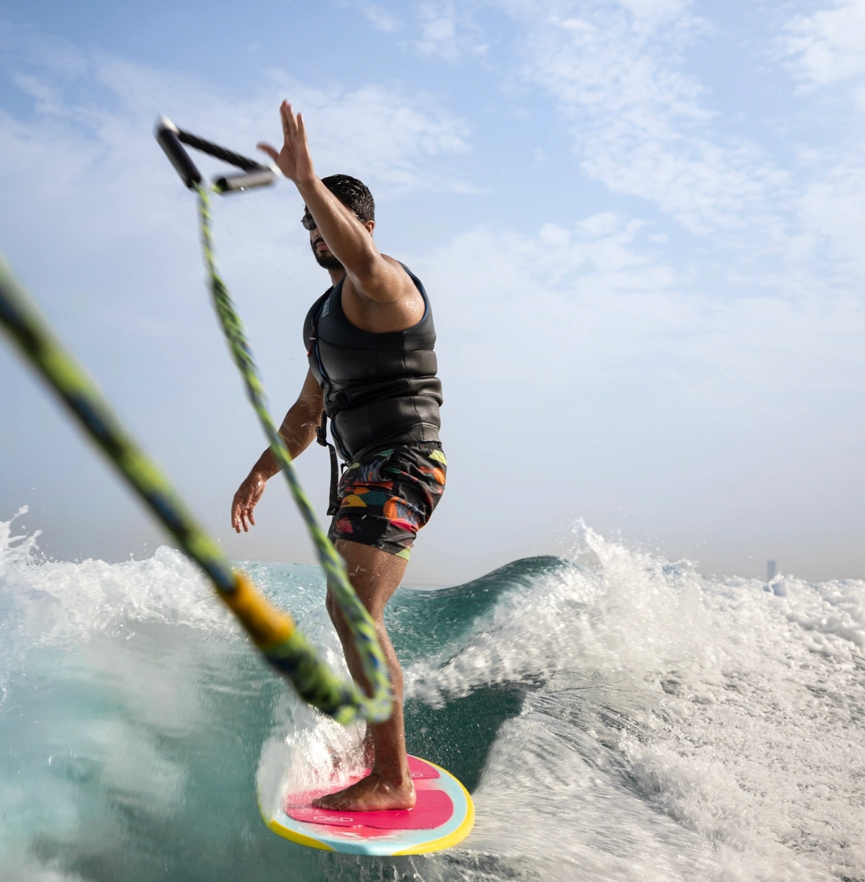 Surfer balancing on board while riding a wave and throwing the rope
