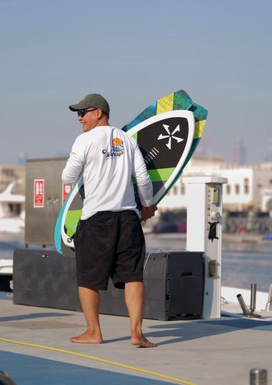 wakesurfing instructor carrying boards