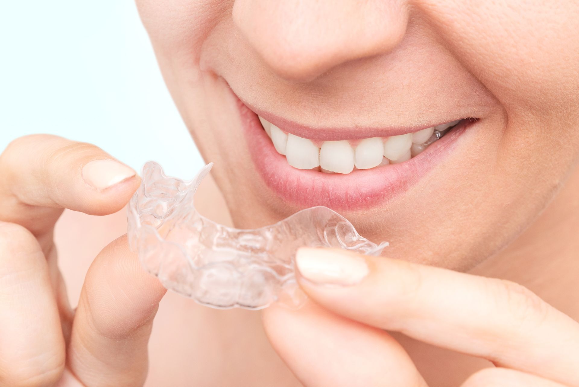 A Close-up View of Someone Holding a Clear Plastic Dental Aligner — Mareeba Dental Centre in Mareeba, QLD