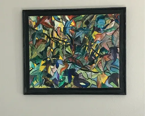 Abstract multicolored framed painting with geometric shapes on a white wall