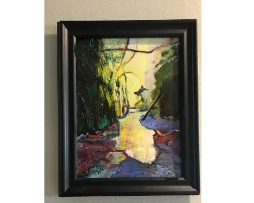Framed painting of a sunlit river or canal with lush green trees and reflected light on the water