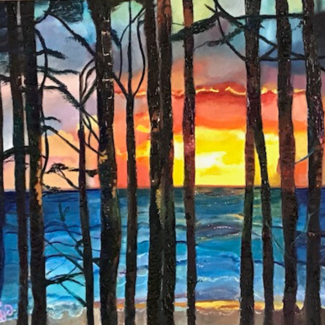 Sunset over a blue lake, seen through tall dark tree trunks, with orange and red sky.