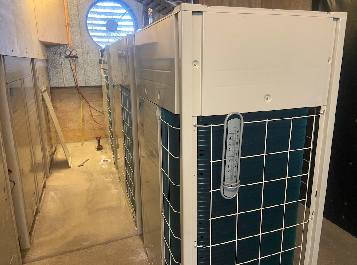 A White Air Conditioner Is Mounted On House — BT Airconditioning In Portsmith, QLD