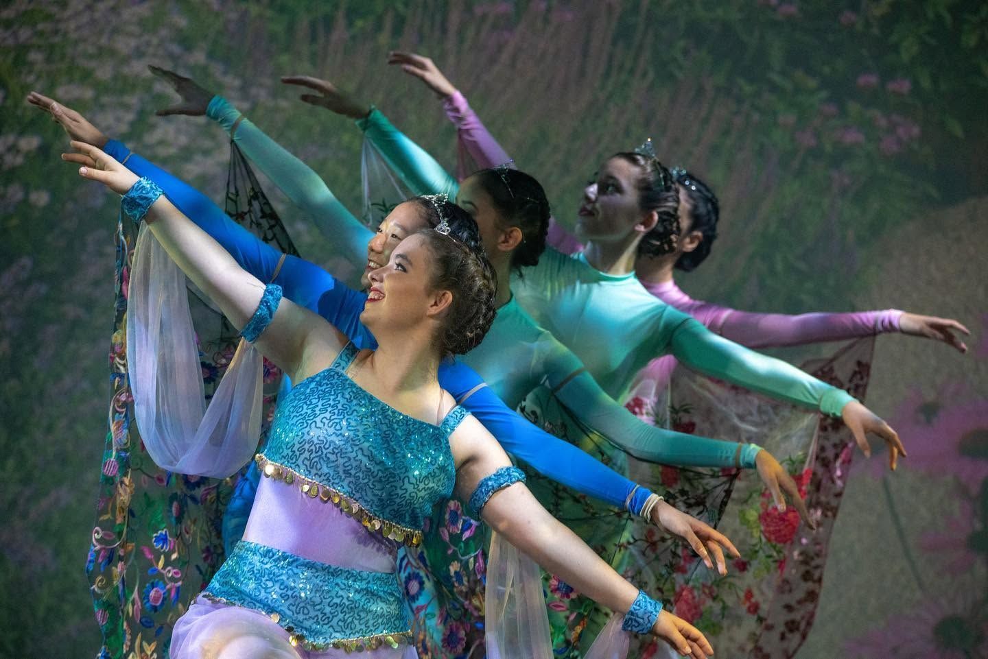 Dancers in Colorful Costumes Pose With Outstretched Arms — Kay Flynn Dancing Academy Southport in Southport, QLD