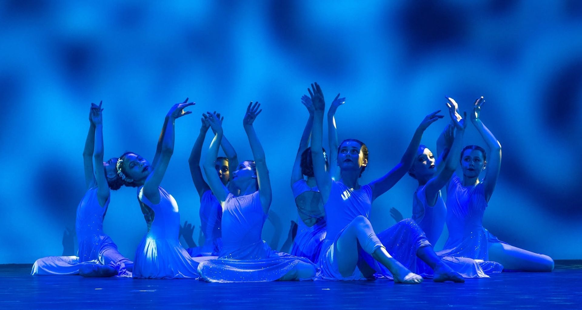 Five Dancers in Blue Costumes Pose With Arms Raised — Kay Flynn Dancing Academy Southport in Southport, QLD