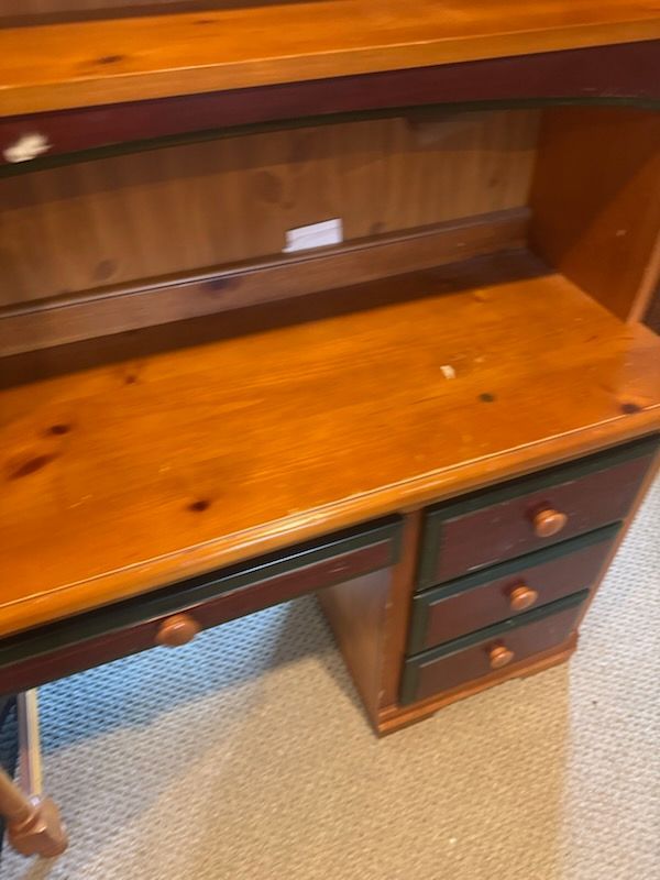 Wooden desk hutch with empty shelves and drawers on a beige carpet