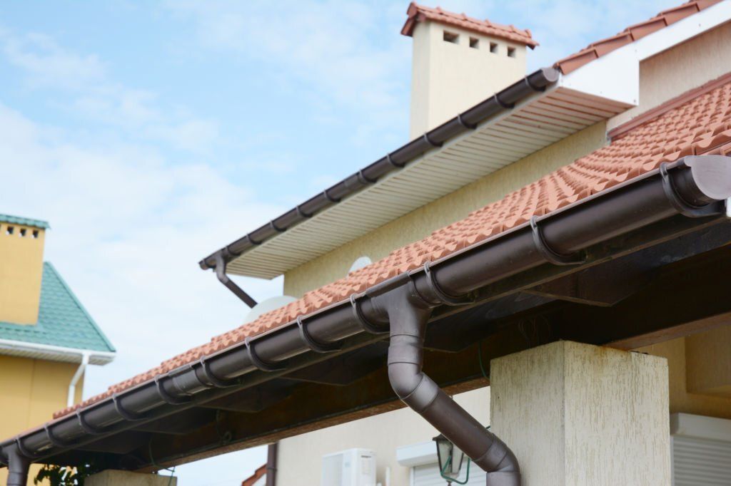 Image of rain gutter with holders and downspout pipe