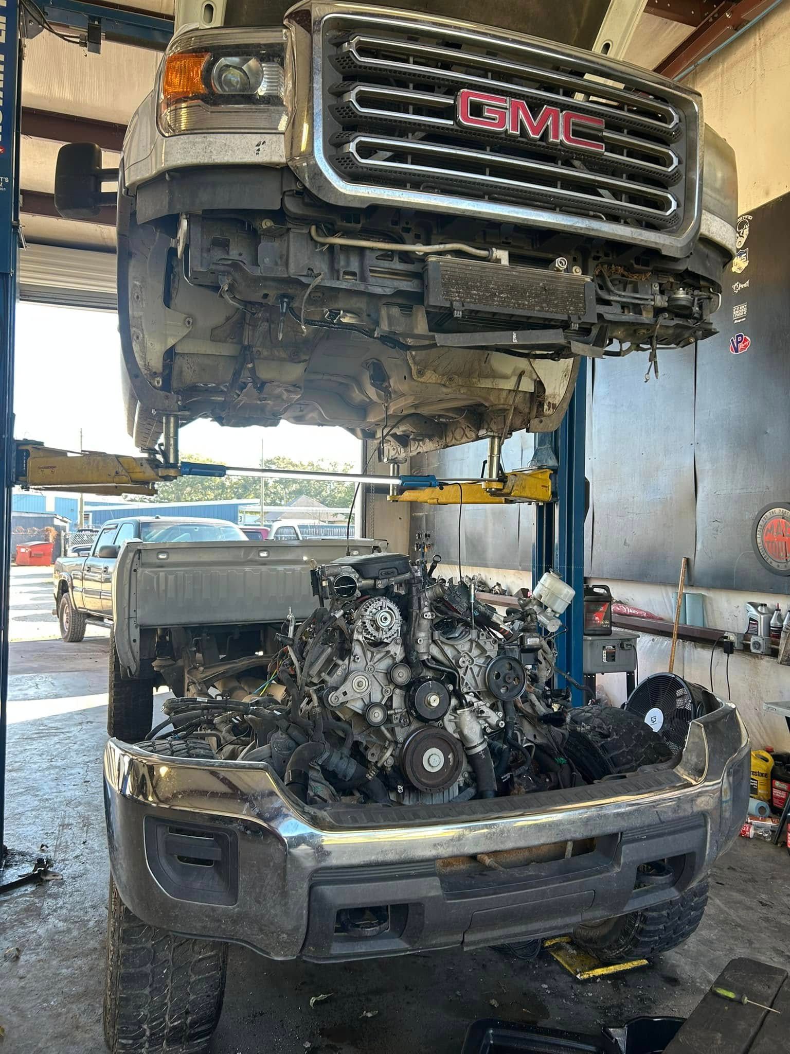 A gmc truck is being worked on in a garage.