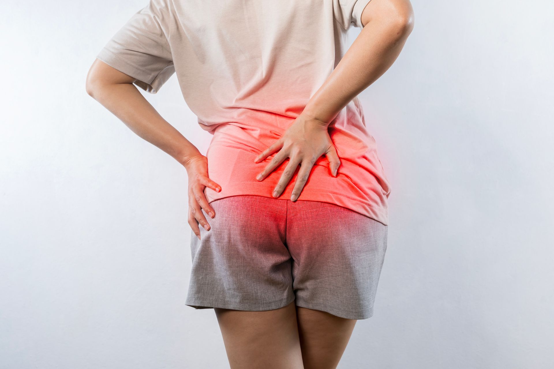 A woman is holding her hip in pain.