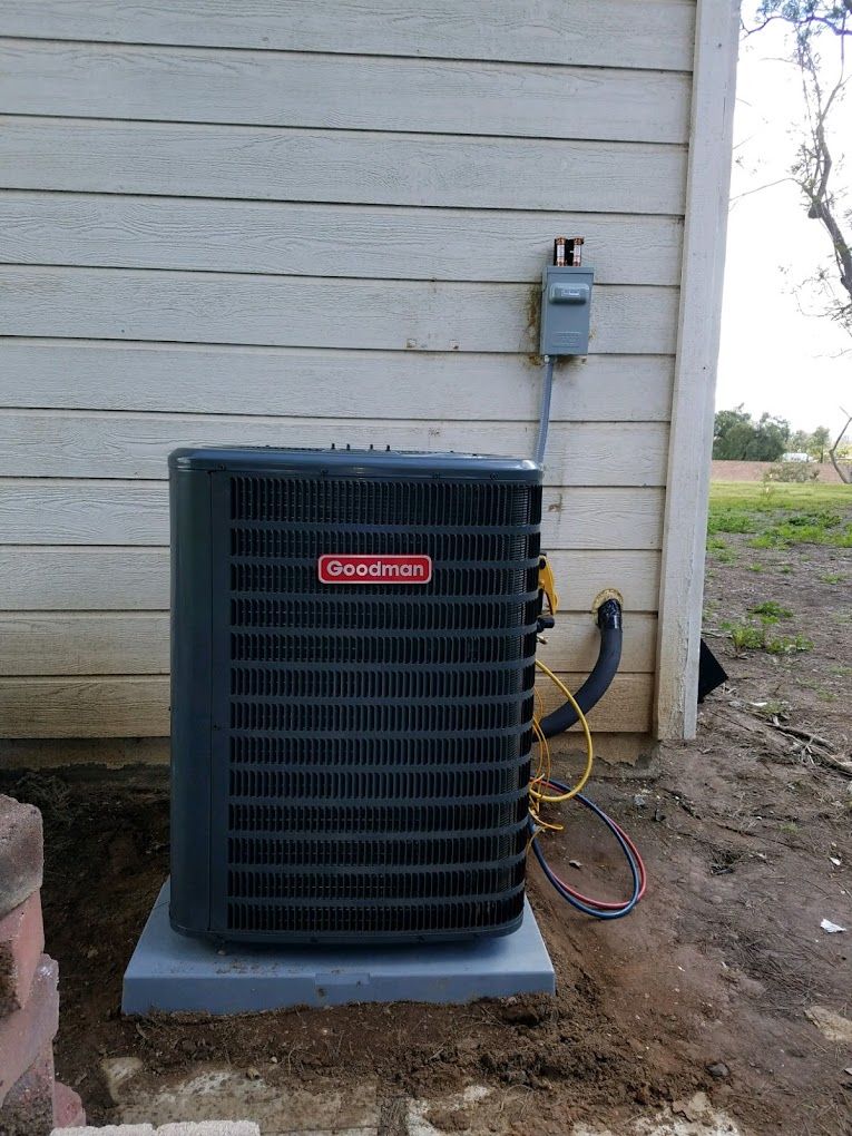 An air conditioner is sitting on the side of a house.