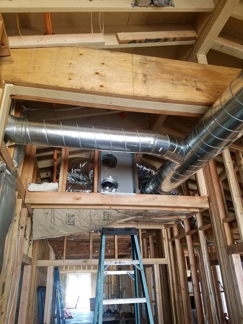 A ladder is sitting in the middle of a house under construction.