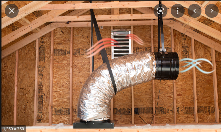 Insulated HVAC duct suspended in an unfinished attic with exposed wooden rafters and framing.