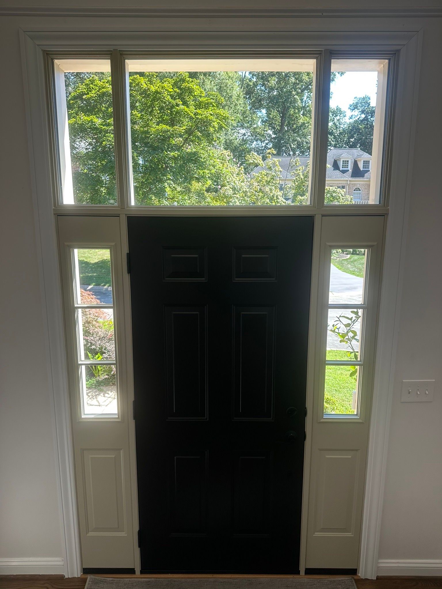 Front entry with a black door, white sidelights, and a transom window above.