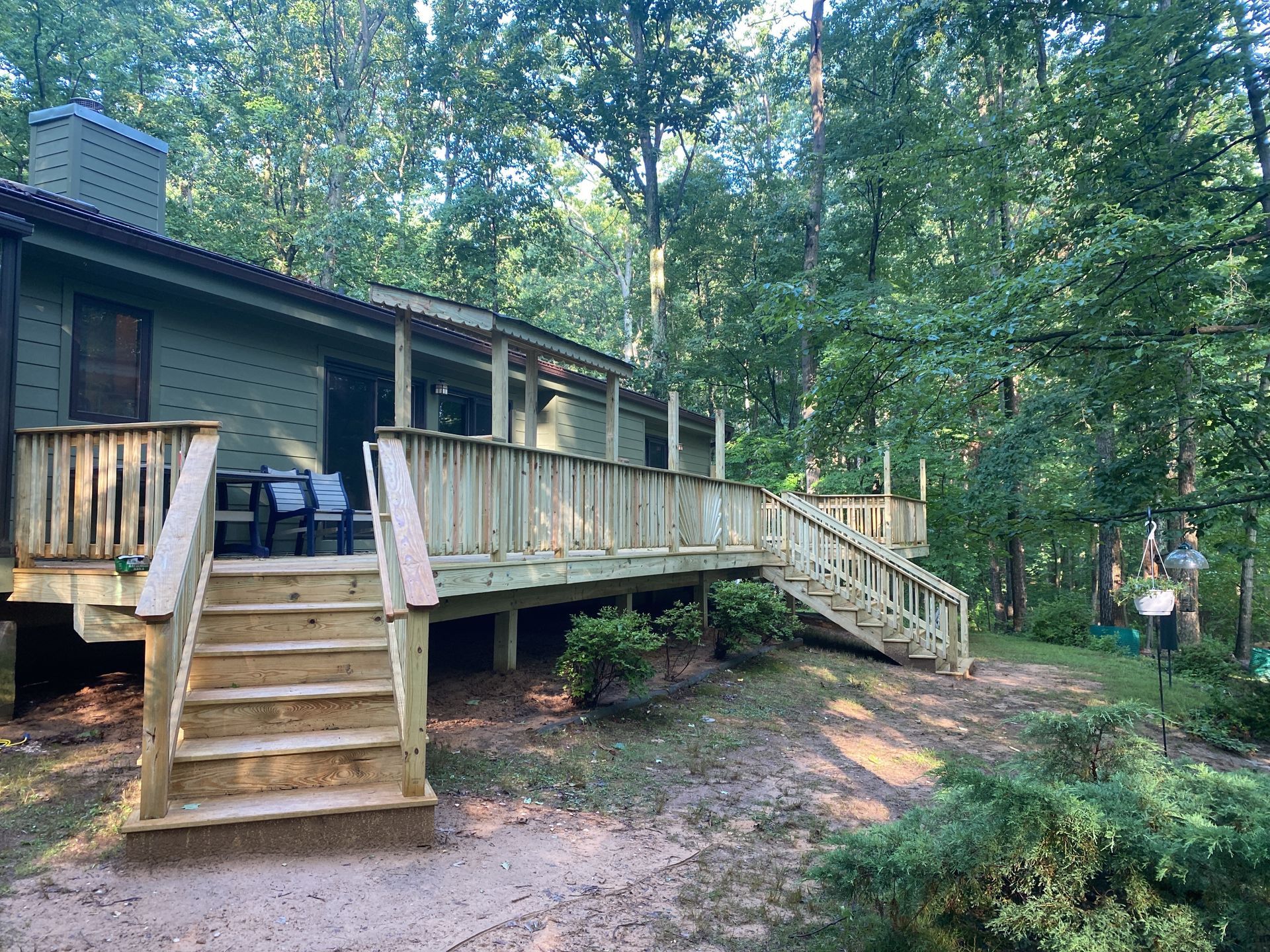 Wooden cabin deck with stairs and railing in a wooded forest clearing