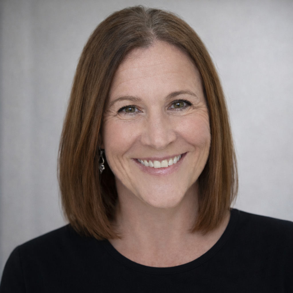 Smiling woman with shoulder-length brown hair against a gray background
