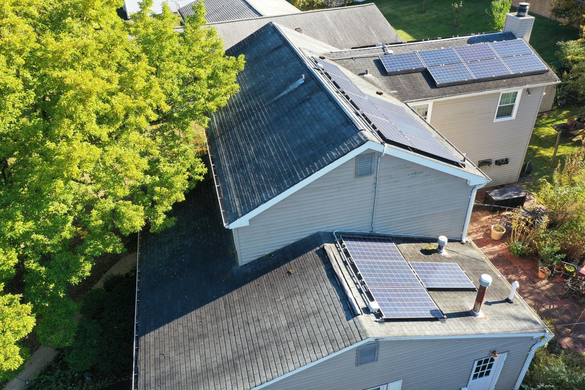 Aerial view of several gray-roofed houses surrounded by trees