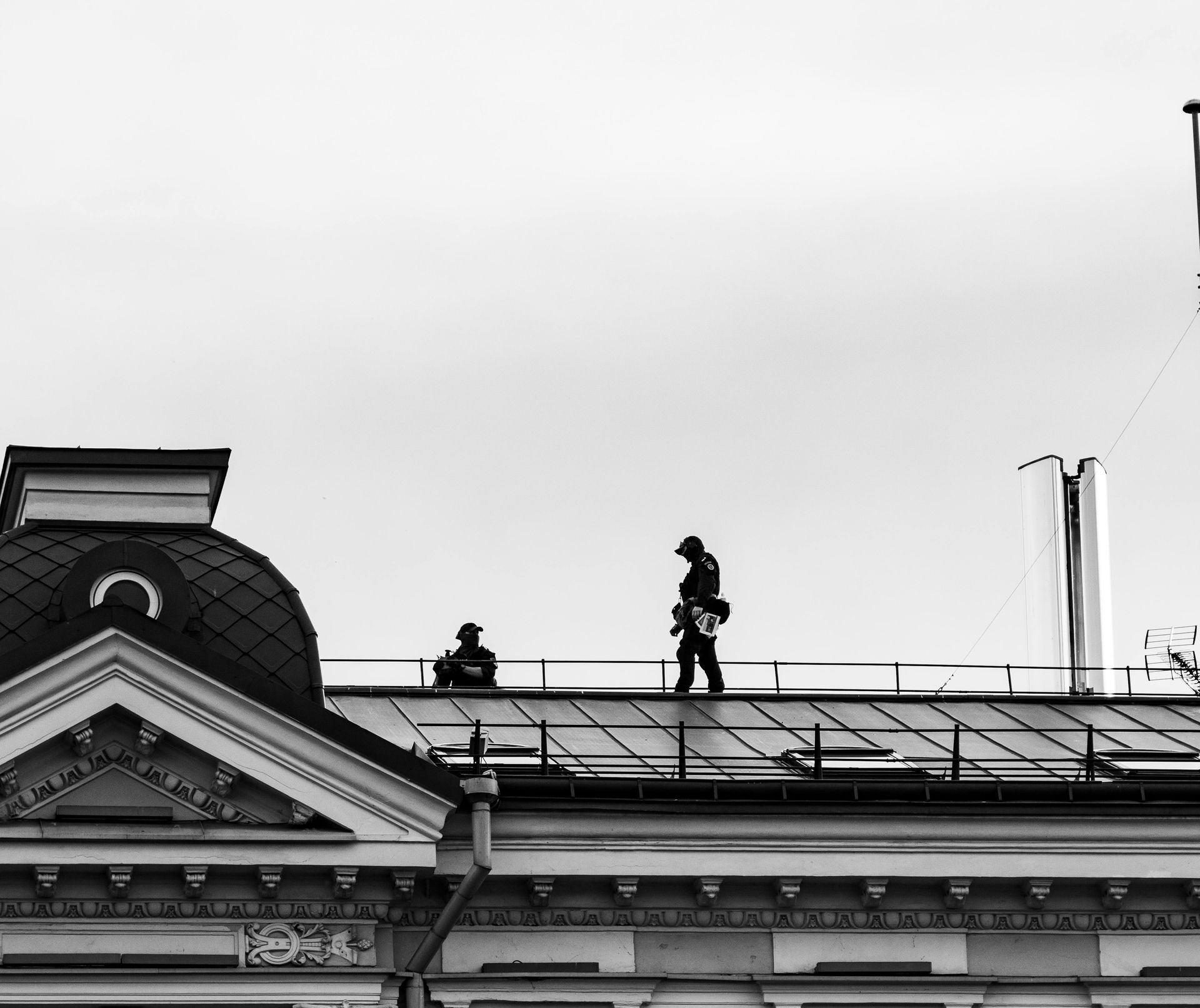 two men on top of roof performing an inspection