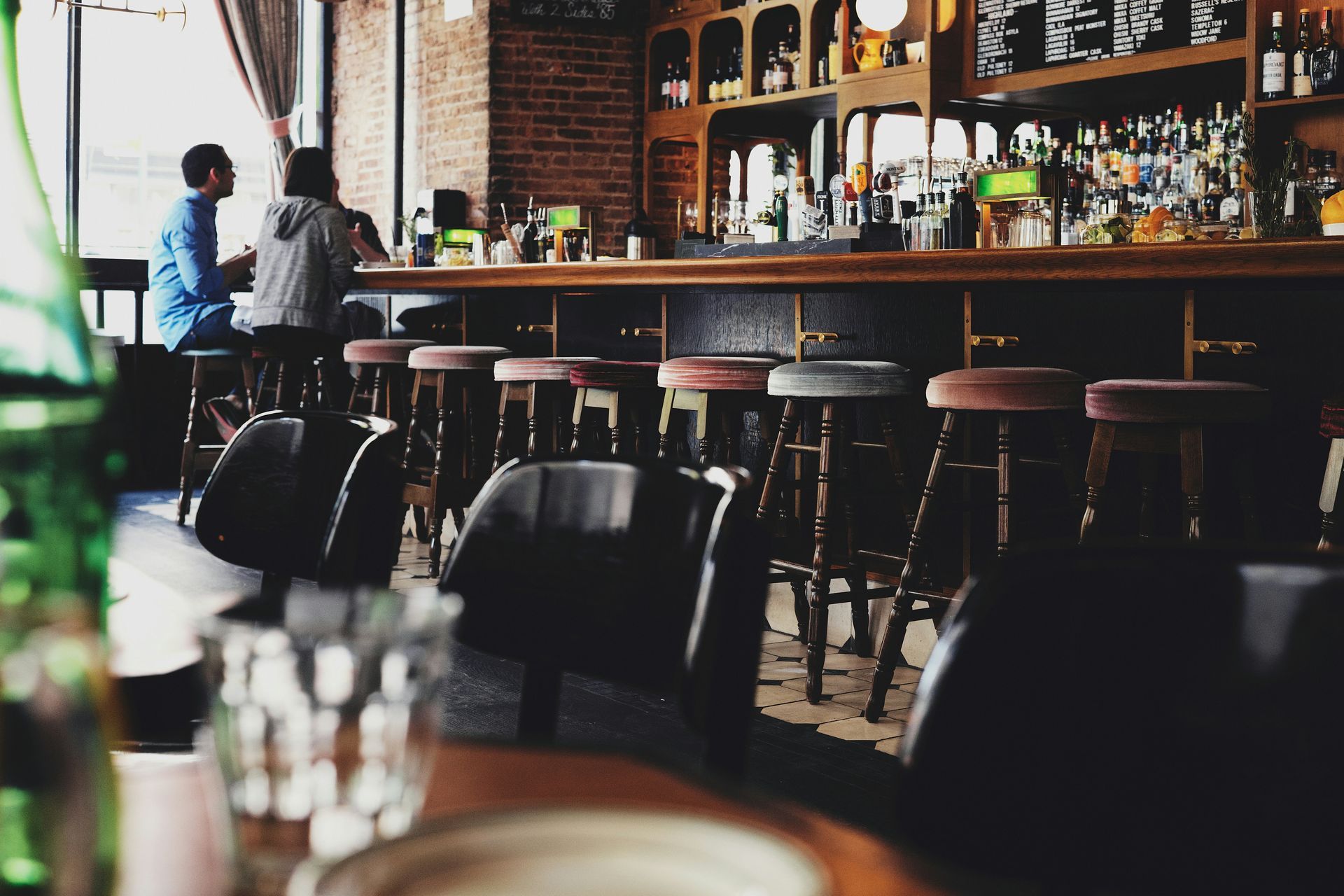 A group of people are sitting at a bar in a restaurant.